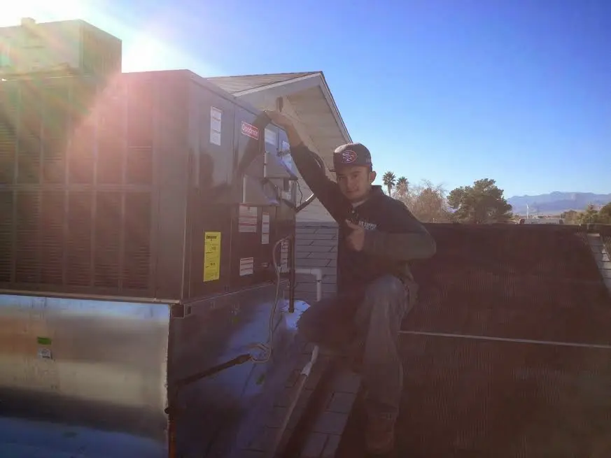 HVAC technician performing Heat Pump Repair on a rooftop unit in St. Joseph